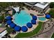 Aerial view of resort-style pool with multiple umbrellas and lounge chairs at 6399 W Saratoga Way, Florence, AZ 85132