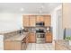 L-shaped kitchen with granite countertops and wood cabinets at 6535 E Superstition Springs Blvd # 124, Mesa, AZ 85206