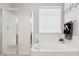 Bright bathroom featuring a soaking tub with a swan faucet, a frosted glass shower, and a decorative flower at 7307 E Texas Ebony Dr, Gold Canyon, AZ 85118