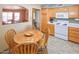 Kitchen with wood cabinets, white appliances and a view into dining area at 7861 E Natal Ave, Mesa, AZ 85209