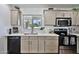 Bright kitchen featuring quartz countertops, gray cabinets, and stainless-steel appliances providing a modern space at 811 W Northern Ave, Phoenix, AZ 85021