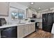 Well-lit kitchen features quartz countertops, shaker cabinets and views to the front yard at 811 W Northern Ave, Phoenix, AZ 85021