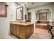 Bathroom featuring tile floor, wooden cabinets, granite countertop, soaking tub and decorative mirror at 8260 E Sunset View Dr, Gold Canyon, AZ 85118