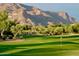 Beautiful golf course view with manicured greens and a stunning mountain range backdrop at 8260 E Sunset View Dr, Gold Canyon, AZ 85118