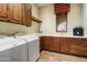 Functional laundry room with wooden cabinetry, modern appliances, and a window offering natural light and a charming view at 8260 E Sunset View Dr, Gold Canyon, AZ 85118
