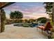 Picturesque backyard patio with a stone walkway leading to a pool with a waterfall, enveloped by lush greenery at 8260 E Sunset View Dr, Gold Canyon, AZ 85118