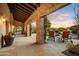 Inviting covered patio with stone columns, lounge chairs, and a serene view of the pool and landscaped yard at sunset at 8260 E Sunset View Dr, Gold Canyon, AZ 85118