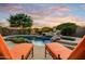 Serene backyard pool with a waterfall feature and comfortable lounge chairs, surrounded by lush landscaping and mature trees at 8260 E Sunset View Dr, Gold Canyon, AZ 85118