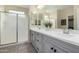 Bathroom with double sinks, light gray cabinets, a large mirror, and frosted glass door shower at 1081 W Brangus Way, San Tan Valley, AZ 85143