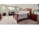 Comfortable bedroom with a dark wood bed frame, sitting area by bay windows, and natural light at 1081 W Brangus Way, San Tan Valley, AZ 85143