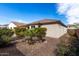 Rear exterior shot of the home featuring well-maintained desert landscaping and a tile roof at 1081 W Brangus Way, San Tan Valley, AZ 85143