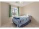 Bedroom with a comfortable-looking bed, tile flooring, and natural light from a large window at 11810 W Belmont Dr, Avondale, AZ 85323