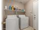 Functional laundry room with washer, dryer, and overhead shelving for storage at 11810 W Belmont Dr, Avondale, AZ 85323