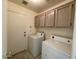 Laundry room with washer, dryer and upper cabinets at 1324 W Michigan Ave, Phoenix, AZ 85023