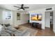 Bright living room with sectional sofa, wood floors, and large TV at 1510 E Mission Ln, Phoenix, AZ 85020