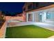 Night view of a backyard with a pool and artificial turf at 16846 W Hilton Ave, Goodyear, AZ 85338