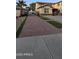 Long red brick driveway with artificial grass accents leading to the home at 16846 W Hilton Ave, Goodyear, AZ 85338