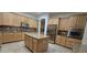 Open kitchen featuring a center island, lots of cabinet space, granite counters, and stainless appliances at 16846 W Hilton Ave, Goodyear, AZ 85338