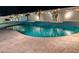 Inviting kidney-shaped pool with waterfalls and string lights at night at 16846 W Hilton Ave, Goodyear, AZ 85338