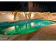 Night view of a kidney-shaped pool with surrounding tile and string lights at 16846 W Hilton Ave, Goodyear, AZ 85338