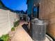 Side yard with pathway, landscaping, and AC units at 16846 W Hilton Ave, Goodyear, AZ 85338