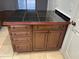 Kitchen island with dark granite countertop and wood cabinets at 1714 N Pleasant Dr, Chandler, AZ 85225