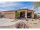 Single-story home with desert landscaping, two-car garage, and covered entryway at 17581 W Canyon Ln, Goodyear, AZ 85338