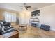 Living room featuring a large TV, comfy seating, and a circular shelving unit at 17581 W Canyon Ln, Goodyear, AZ 85338