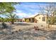 Desert landscaped backyard featuring string lights, covered patio, pool, and unique decorative items at 22717 W Sierra Ridge Way, Wittmann, AZ 85361