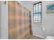 Bathroom featuring shower with curtain, window with blinds, and simple decorations at 22717 W Sierra Ridge Way, Wittmann, AZ 85361