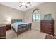 A cozy bedroom with a classic design and a large window with natural light at 22717 W Sierra Ridge Way, Wittmann, AZ 85361