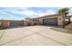 Spacious driveway leading to a three car garage, enhanced by desert landscaping and secure gate at 22717 W Sierra Ridge Way, Wittmann, AZ 85361