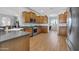 Well-lit kitchen features wood floors and cabinetry, stainless steel appliances, and modern countertops at 22717 W Sierra Ridge Way, Wittmann, AZ 85361