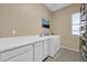 Well-organized laundry room with modern washer and dryer, storage cabinets, and tile flooring at 22717 W Sierra Ridge Way, Wittmann, AZ 85361