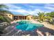 Beautiful backyard pool with blue water, palm trees and a covered patio; great for relaxing and entertaining at 22717 W Sierra Ridge Way, Wittmann, AZ 85361