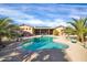 Beautiful backyard pool with blue water, palm trees and a covered patio; great for relaxing and entertaining at 22717 W Sierra Ridge Way, Wittmann, AZ 85361