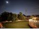 Night view of backyard with trees, pool and lights at 2401 E Christy Dr, Phoenix, AZ 85028