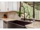 Kitchen with a farmhouse sink, gooseneck faucet, white cabinets, stone counters, and under-mount lighting at 2401 E Christy Dr, Phoenix, AZ 85028