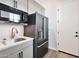 Compact kitchenette with stainless steel sink and black appliances at 25232 S Pyrenees Ct, Queen Creek, AZ 85142