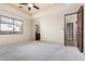 Bright bedroom featuring neutral carpet, a ceiling fan, and doorways to the bathroom and walk-in closet at 3254 N Ladera Cir, Mesa, AZ 85207