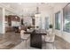 Elegant dining area featuring a sleek table, modern chandelier, and open layout adjacent to a gourmet kitchen at 3254 N Ladera Cir, Mesa, AZ 85207