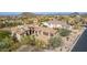 Aerial view of home's front exterior with desert landscaping, three car garage, and tile roof at 3254 N Ladera Cir, Mesa, AZ 85207