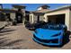 A beige stucco home with a beautiful brick driveway showing off classic and modern sports cars at 3254 N Ladera Cir, Mesa, AZ 85207