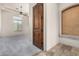 Hallway with tile flooring, wood door, and a view into a carpeted room at 3254 N Ladera Cir, Mesa, AZ 85207