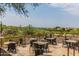 Outdoor patio featuring multiple tables and chairs with views of the surrounding golf course and landscape at 3254 N Ladera Cir, Mesa, AZ 85207