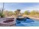 Backyard view of pool, spa, and fire pit features with desert landscaping at 3254 N Ladera Cir, Mesa, AZ 85207