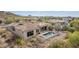 Aerial view of home's rear exterior with pool, hot tub, rooftop access, and desert landscape at 3254 N Ladera Cir, Mesa, AZ 85207