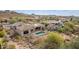 Aerial view of home's rear exterior with refreshing pool, hot tub, desert landscape, and distant mountain views at 3254 N Ladera Cir, Mesa, AZ 85207