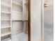 Walk-in closet with custom shelving and access to the bedroom with ceiling fan and neutral carpeting at 3254 N Ladera Cir, Mesa, AZ 85207