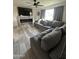 Inviting living room featuring a comfortable gray sofa, a large window, and a cozy fireplace for relaxing evenings at 36014 N 3Rd St, Phoenix, AZ 85086